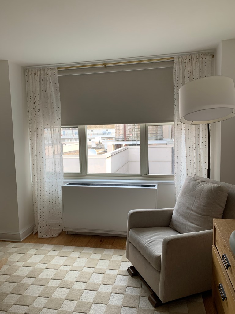 Image of a nursery with blackout shades rolled down half way