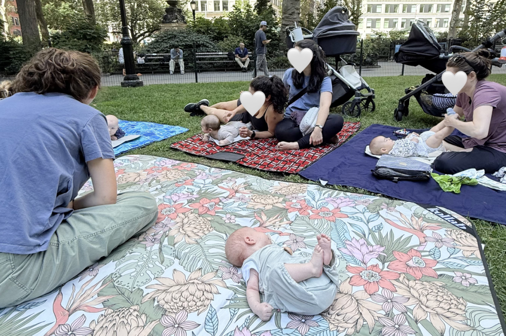 Image of mothers sitting on picnic mats with their babies in NYC